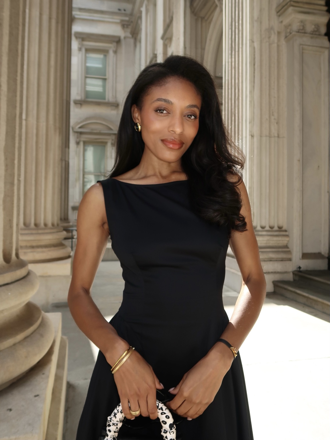 Remonia in a black dress among classical stone columns